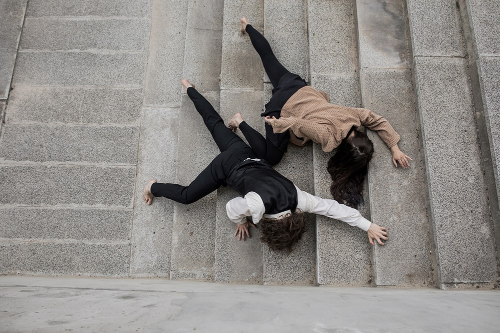 fotografia: dwie osoby leżące na schodach sfotografowane z góry