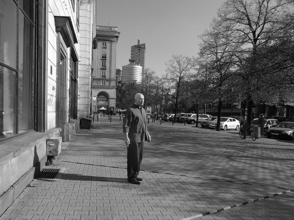 fotografia czarno biała mężczyzna zygmunt piotrowski stoi na chodniku przed galerią xx1